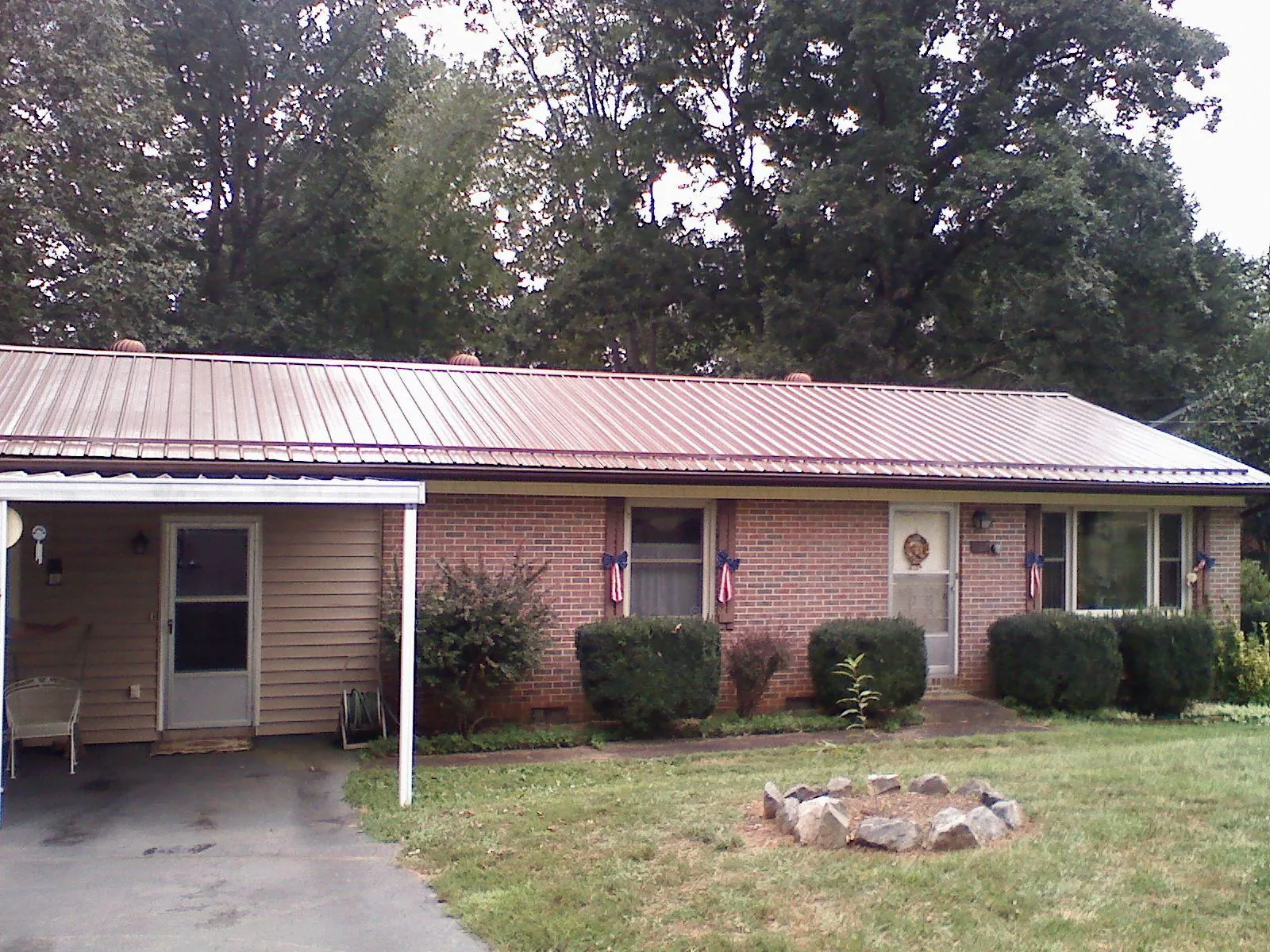 Bronze metal roof and carport on a brick ranch home — Roof Repair work by our crew in Cabin John